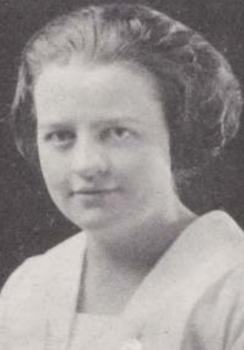 A young white woman, wavy hair bobbed and brushed back from face; wearing a white blouse or dress