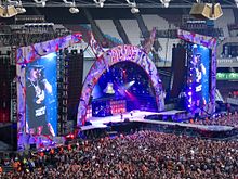 AC/DC s Axlem Rosem vystupují na olympijském stadionu v Londýně.