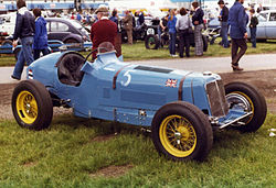 Bira's second ERA racing car, R5B Remus, in an intermediate livery of blue with yellow wheels only. The UK flag is placed in the position of honour, at the right leading edge of the car's bonnet, to represent its manufacturer