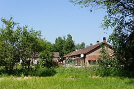 Groupe de maisons aperçu entre les arbres.