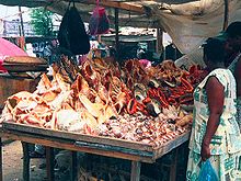 Photo of a vendor in Tanzania in 2000 selling to tourists threatened species seashells which have been taken alive from the sea, killing the animal inside. Seashell vendor.jpeg