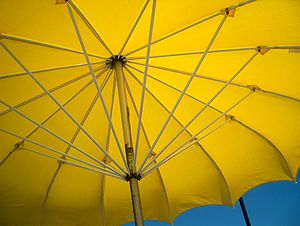 Yellow beach umbrella in the summer sun.