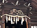 神殿のしめ縄の上にある松と鳥の彫刻