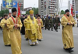 Russian Orthodox subdeacons (red stoles) surrounding a bishop. Cross Procession in Novosibirsk 05.jpg