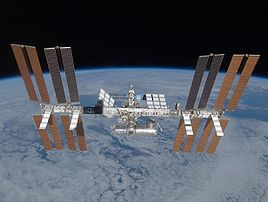 La station spatiale internationale, vue depuis la navette spatiale Discovery, au cours de la mission STS-119. Sur cette photographie prise alors que la navette quitte la station internationale, on peut voir les quatre paires de panneaux solaires alignés sur la poutre centrale de la station. Sur la gauche se trouve le segment S6 qui vient d'être ajouté. (définition réelle 2 464 × 1 856)