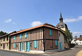 A timbered building and the church tower in Magescq