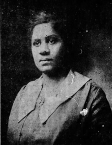 Black woman wearing dress with wide pointed collar