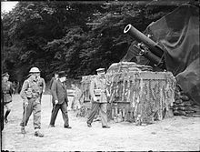Winston Churchill sur une plage, en compagnie d'officiers de l'armée britannique, devant un obusier.