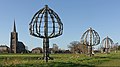 Batenburg, sculpture (de Boombeelden) designed by Marc de Roover with church (de Sint Victorkerk) in the background