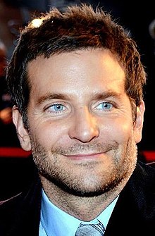 Foto Bradley Cooper, saat ia tersenyum menjauh dari kamera.