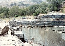 Roques ígnies en capes de cromitita negra i anortosita grisa a la zona del complex ígneu de Bushveld a l'aflorament del riu Mononono, prop de Steelpoort, província de Limpopo, Sud-àfrica.