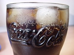 Um copo com Coca-Cola e gelo.