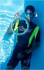 An underwater diver blows a bubble ring.