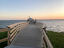 A pier extended over Lake Ponchatrain Waters with wooden decks.