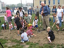 children and adults digging a patch of ground