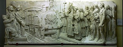 La Benedicció del tren, (XIXe siècle), Francesc Pagès i Serratosa (Barcelone, 1852-1899) Relief original en plâtre, socle de l'allégorie du chemin de fer en bronze sur la façade du palais de justice de Barcelone. Il est conservé au musée Mataró (numéro de catalogue MCMM 5415).