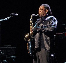 Musician Clarence Clemons onstage and playing a saxophone in front of a microphone