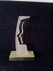 Glas auf Holzsockel, Beschriftung des Sockels: Deutscher Synchronpreis 2021, Ehrenpreis, Sonja Deutsch