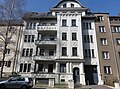 Mietshaus in geschlossener Bebauung mit Vorgarten und Einfriedung