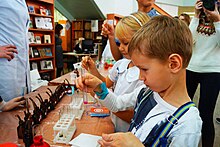 Children mix different chemicals in test tubes as part of a science education program. Festival of Science in Samara.jpg