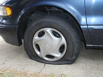 A flat tire on a Mercury Villager van.