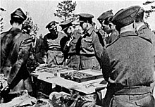 Eight soldiers in World War II-era uniforms, as per caption