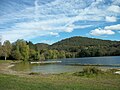 Lac de Barbazan avec tapis de nénuphar jaune sur la droite.