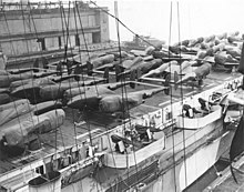 Cocooned Lockheed P-38 Lightnings and North American Aviation P-51 Mustangs line the decks of a U.S. Navy Escort "Jeep" Carrier (CVE) ready for shipment to Europe from New York. Lockheed P-38 Lightnings on CVE.jpg