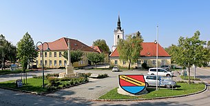 Ortszentrum mit Marienstatue, Schule, Pfarrhof und Kirche