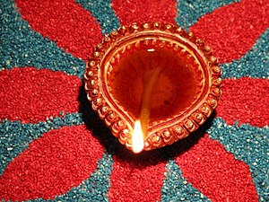 Burning oil lamp on a colourful rangoli design...