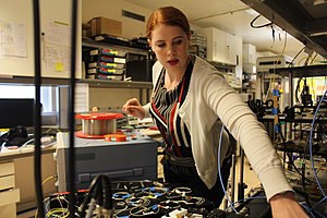 A female engineer working on an optical communications system test. Working at an optical communications system testbed.jpg