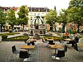 Gutenbergplatz – Platzanlage mit Lindenpflanzung, Bedürfnisanstalt, Brunnen und Blechhaube einer Litfaßsäule