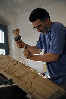 Hans-Georg Wagner arbeitet mit Holzbeitel und Klöppel an einer Skulptur