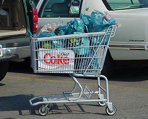 A shopping cart filled with bagged groceries l...