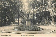 Photographie en noir et blanc représentant une statue en bronze au milieu d'un square avec des arbres en arrière-plan