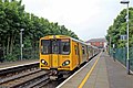 A Merseyrail Class 507 waits at the station.