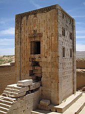 A close up view of the Ka'ba-ye Zartosht ("Cube of Zoroaster") showing the stairs, the narrow opening, and the blind windows. Note its placement in a depression, as well as the unique rectangular markings on the facade Tour nagsh-e-rostam iran.jpg