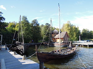 Vikingaskepp, i bakgrunden Almerekoggen och båthuset med torn