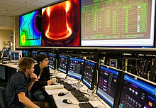 Control room of the Alcator C-Mod tokamak at the MIT Plasma Science and Fusion Center. Alcator C-Mod graduate students in control room.jpg