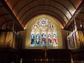 Stained glass window above the altar with organ pipes on either side