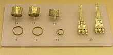 Finds from an early geometric Cremation Burial of a pregnant wealthy woman, from the N.W. of the Areopagus, about 850 BC, Ancient Agora Museum (Athens); exhibit 14-16: broad gold finger rings; exhibit 17-19: gold finger rings; 20: pair of gold earrings with trapezoid endings Early Geometric Jewelry from the Areopagus of Athens. Ancient Agora Museum of Athens.jpg