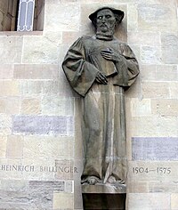 Sculpture de Heinrich Bullinger sur la façade de la Grossmünster à Zurich.