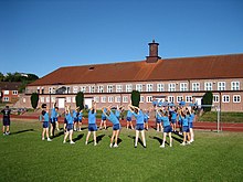 Cadets of the German Navy exercising in front of one of the gyms of Germany's naval officers school, the Marineschule Murwik MSM-sporthalle.jpg