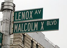 Two green street signs, one reading Lenox Avenue, the other reading Malcolm X Boulevard