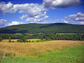 Big mountain with valley in the foreground in the summertime.