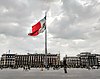 Panorama de la place de la Constitution à Mexico, terminus du Camino Real ; un drapeau mexicain monumental flotte au centre de la photographie.