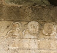 Détails (trois masques ?) du portail roman (XIIe siècle) de l'église.