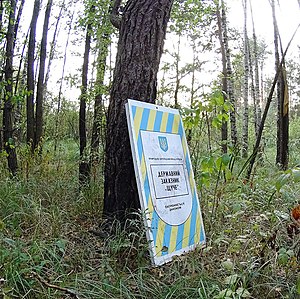 Знак Щучого за 50 метрів до болота, біля лісової дороги на сході від заказника