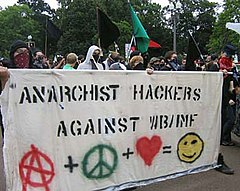 An anarchist protest, showing anarchist and pacifist symbolism Anarchisthackersprotest.jpg