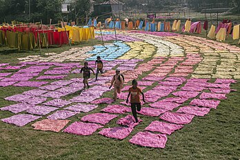 Crianças brincando entre panos coloridos estendidos para secar após o tingimento, Bangladesh. (definição 5 184 × 3 456)